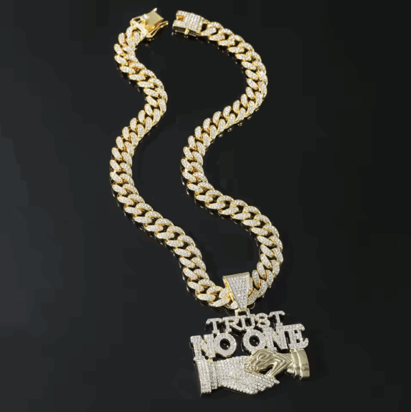 Goldene Iced Out Halskette mit „Trust No One“-Anhänger und Handschlag-Motiv auf weißem Hintergrund